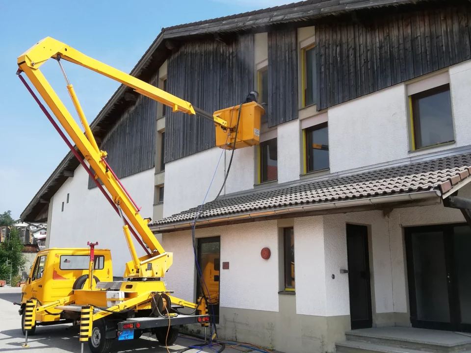 Hebebühne in Position zum Softstrahlen einer Holzfassade