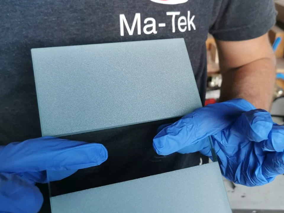 Plaques de verre dépolies par microbillage, présentées par un opérateur Ma-Tek