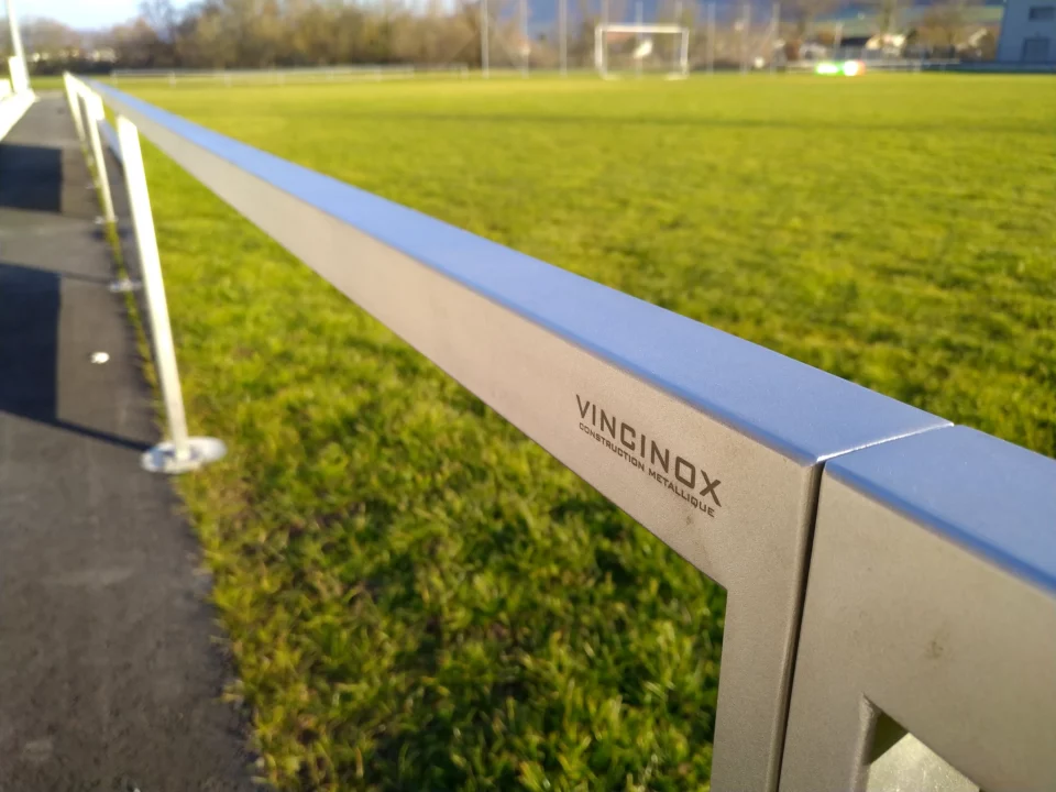 Main courante en inox microbillée au bord d'un terrain de sport