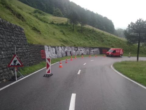 Besprayte Stützmauer vor dem Nassstrahlen