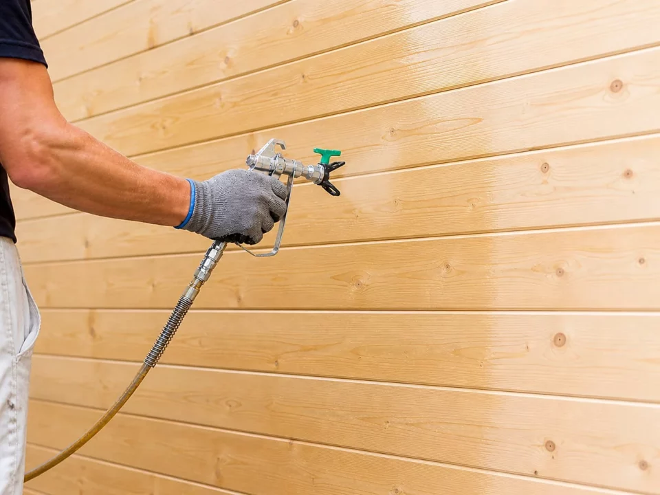 Application d’une huile de protection par giclage sur un lambris en bois clair
